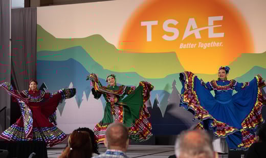 Cultural dances performing in front of a color backdrop that says: TSAE Better Together