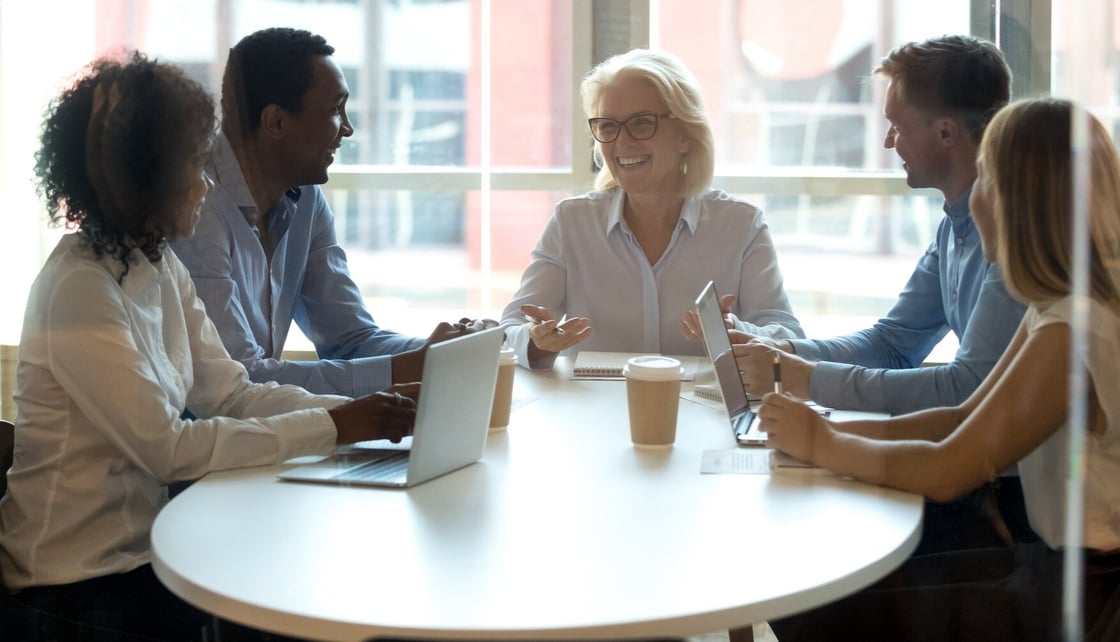 Group of people sitting at a round table having a discussion
